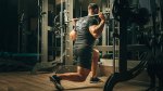 Man with muscular legs performing a hatfield split squat for his smith machine leg workout